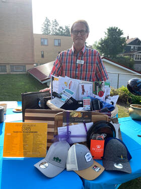 Jeff Meland standing with basket full of donated prizes.